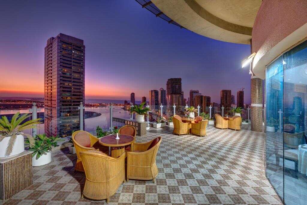 Rooftop terrace at Aryana Hotel overlooking Sharjah at sunset